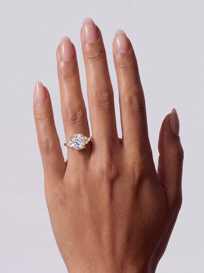 Adeline – Cushion Solitär Verlobungsring mit Seitensteinen in Gelbgold, getragen an der Hand | Élysée Diamonds