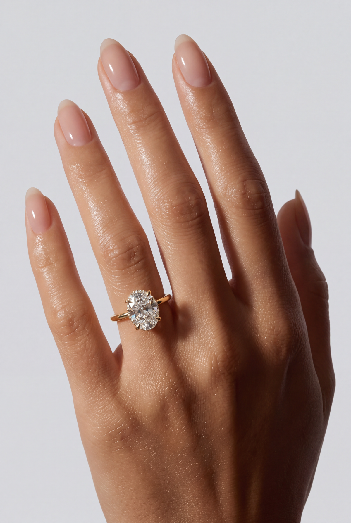 Selene – Ovaler Solitär Verlobungsring mit Hidden Halo in Gelbgold, getragen an der Hand | Élysée Diamonds