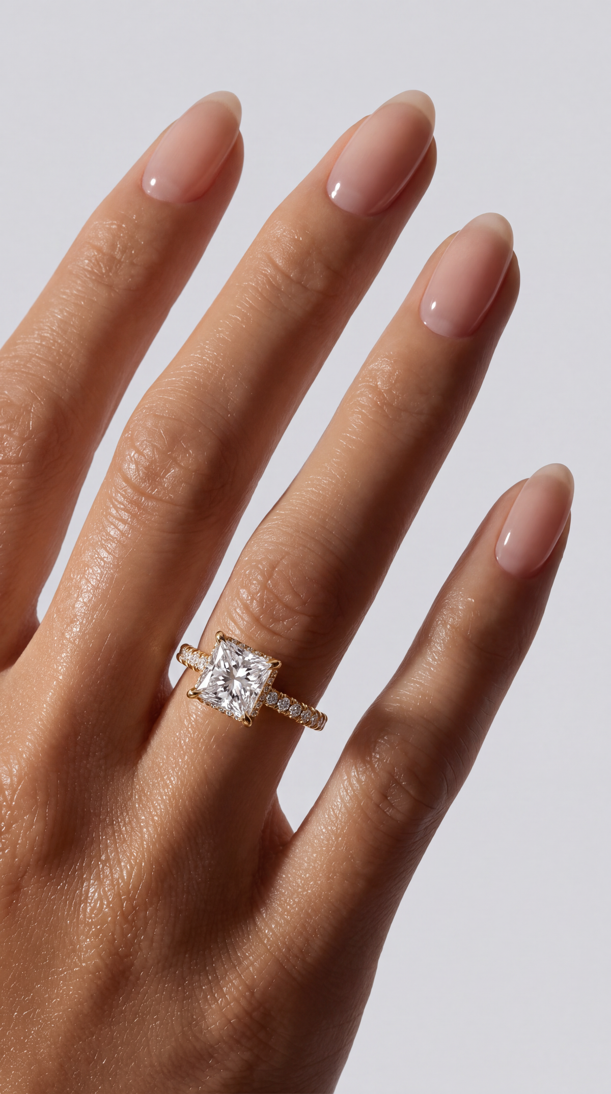 Amara – Princess Verlobungsring mit Hidden Halo & Pavé in Gelbgold, getragen an der Hand | Élysée Diamonds