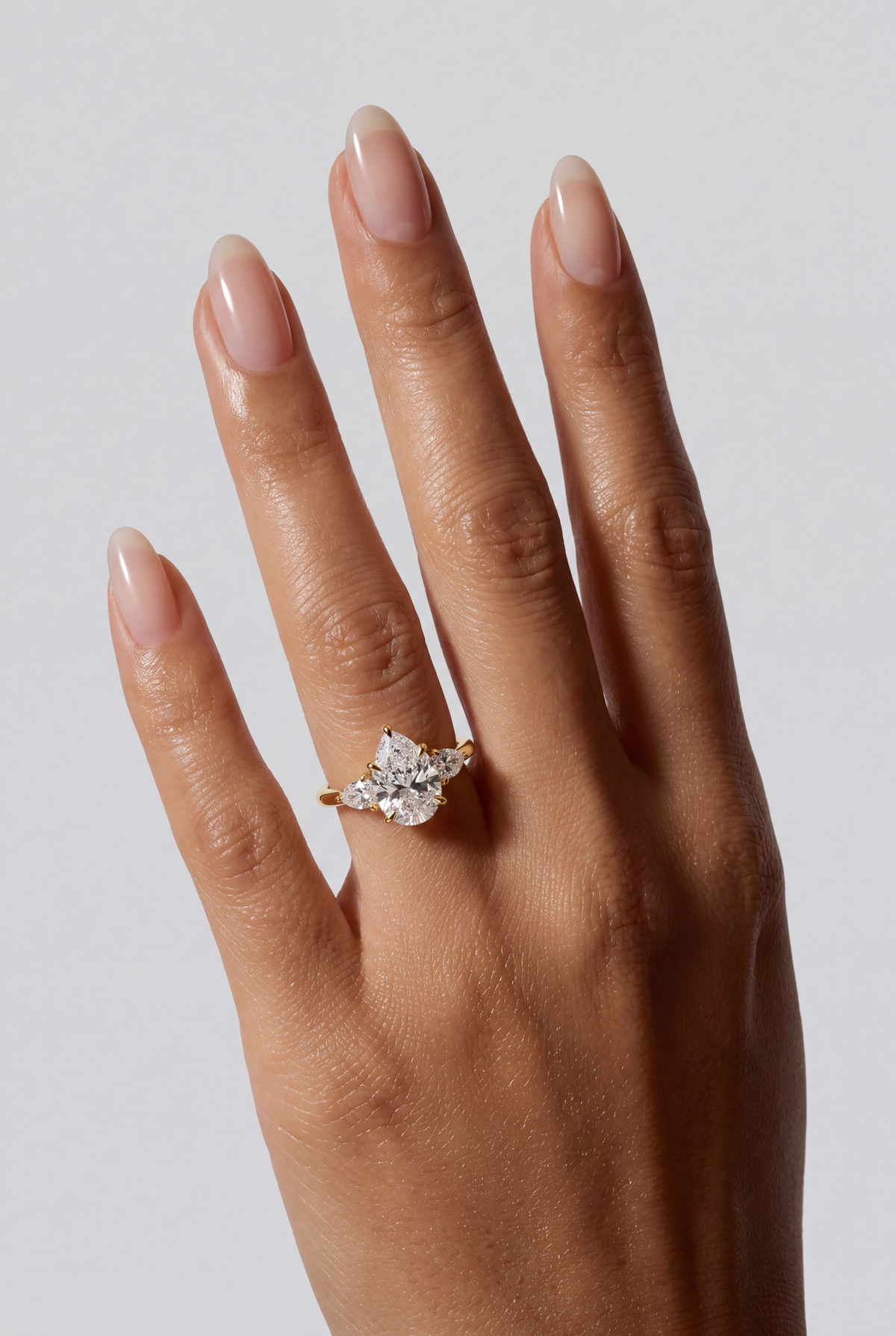 Serelle – Pear Trilogy Verlobungsring in Gelbgold, getragen an der Hand | Élysée Diamonds