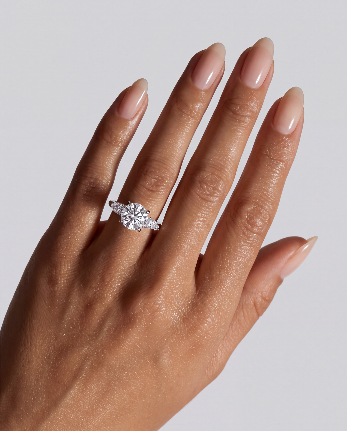 Sorelle – Runder Trilogy Verlobungsring in Weißgold, getragen an der Hand | Élysée Diamonds
