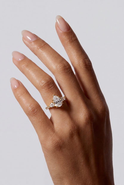 Avelia – Pear Trilogy Verlobungsring mit Pavé in Gelbgold, getragen an der Hand | Élysée Diamonds