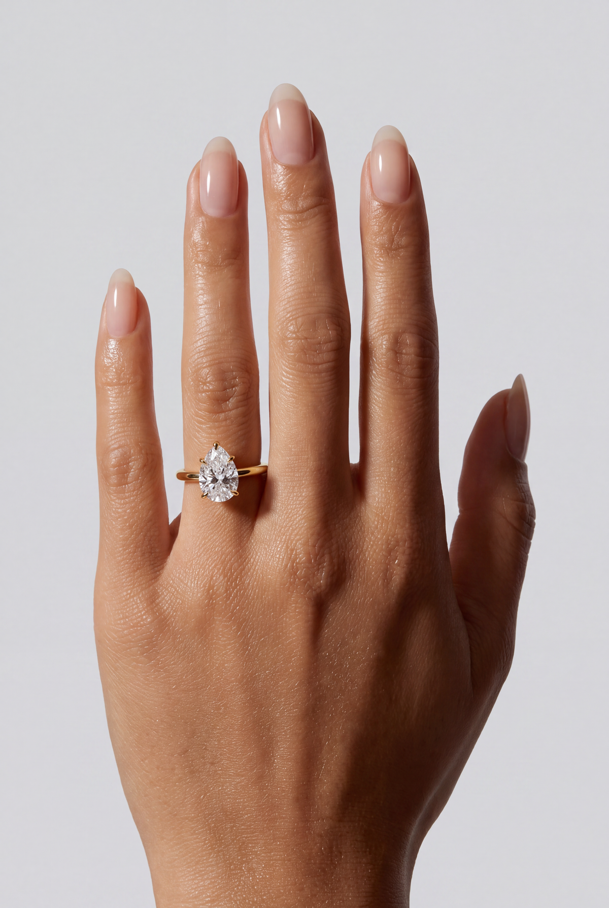 Valora – Pear Solitär Verlobungsring in Gelbgold, getragen an der Hand | Élysée Diamonds
