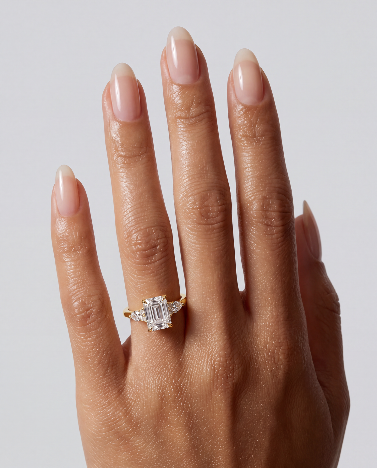 Aurora – Emerald Trilogy Verlobungsring in Gelbgold, getragen an der Hand | Élysée Diamonds