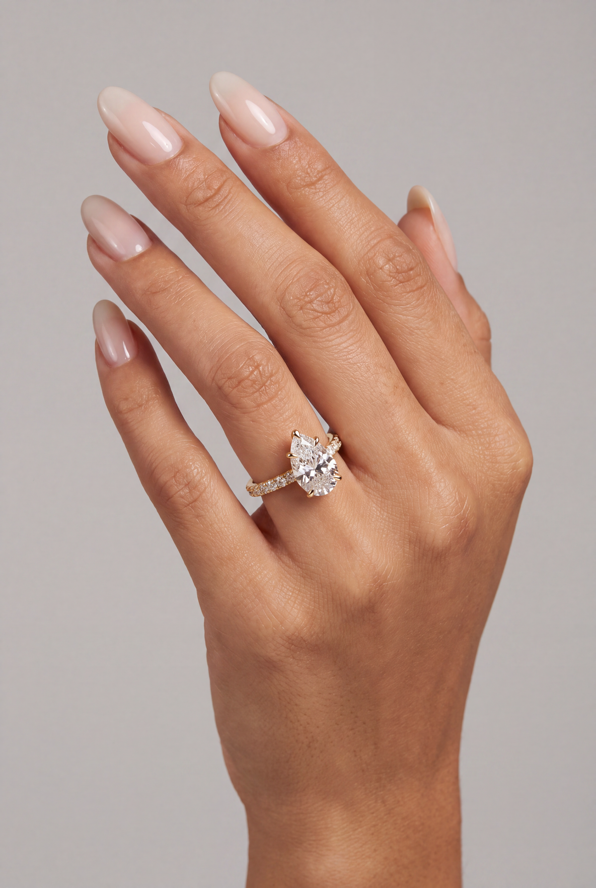 Elara – Pear Solitär Verlobungsring mit Pavé in Gelbgold, getragen an der Hand | Élysée Diamonds