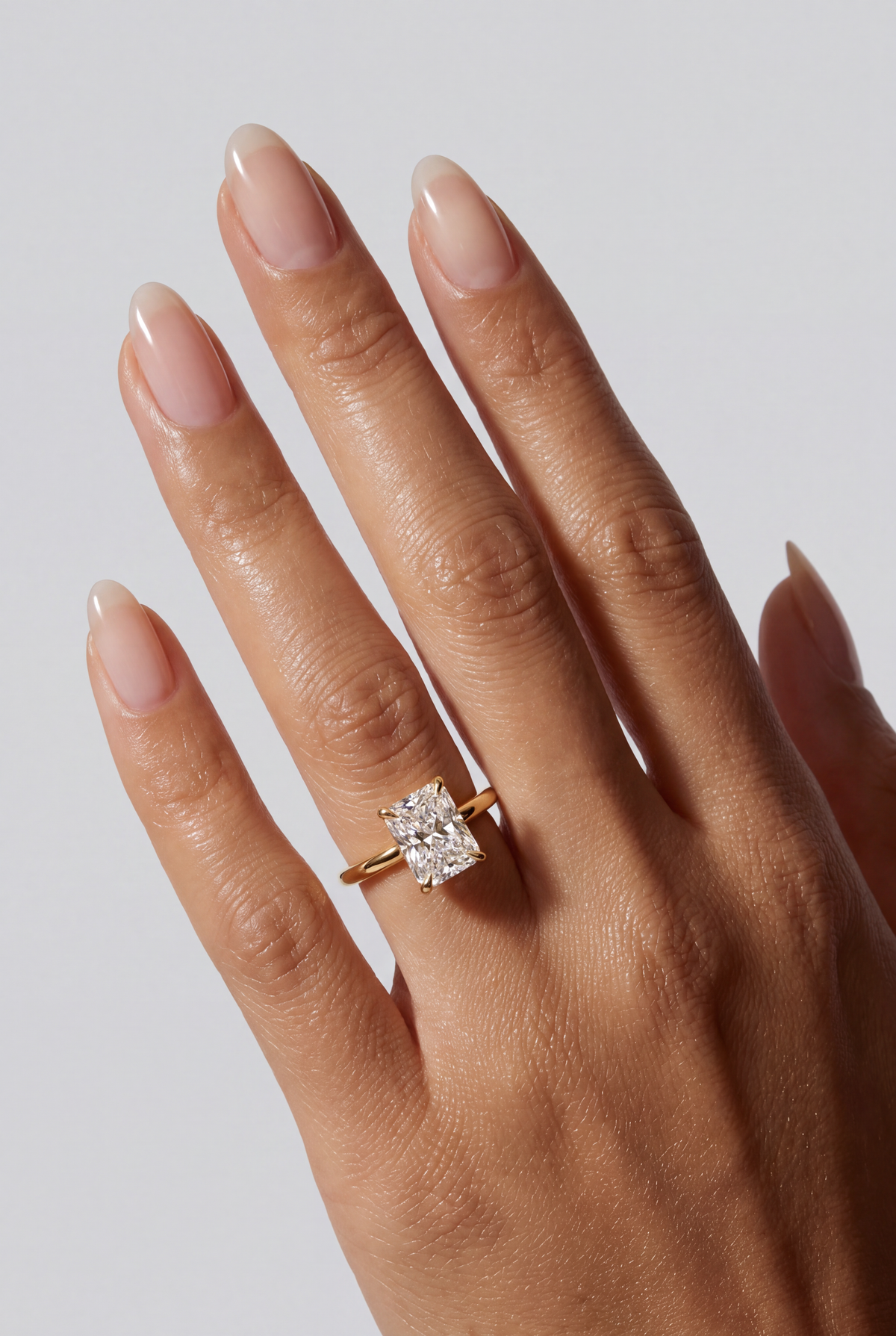 Mariah – Radiant Solitär Verlobungsring in Gelbgold, getragen an der Hand | Élysée Diamonds