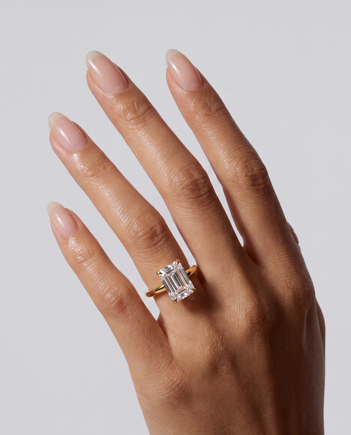 Celine – Emerald Solitär Verlobungsring in Gelbgold, getragen an der Hand | Élysée Diamonds