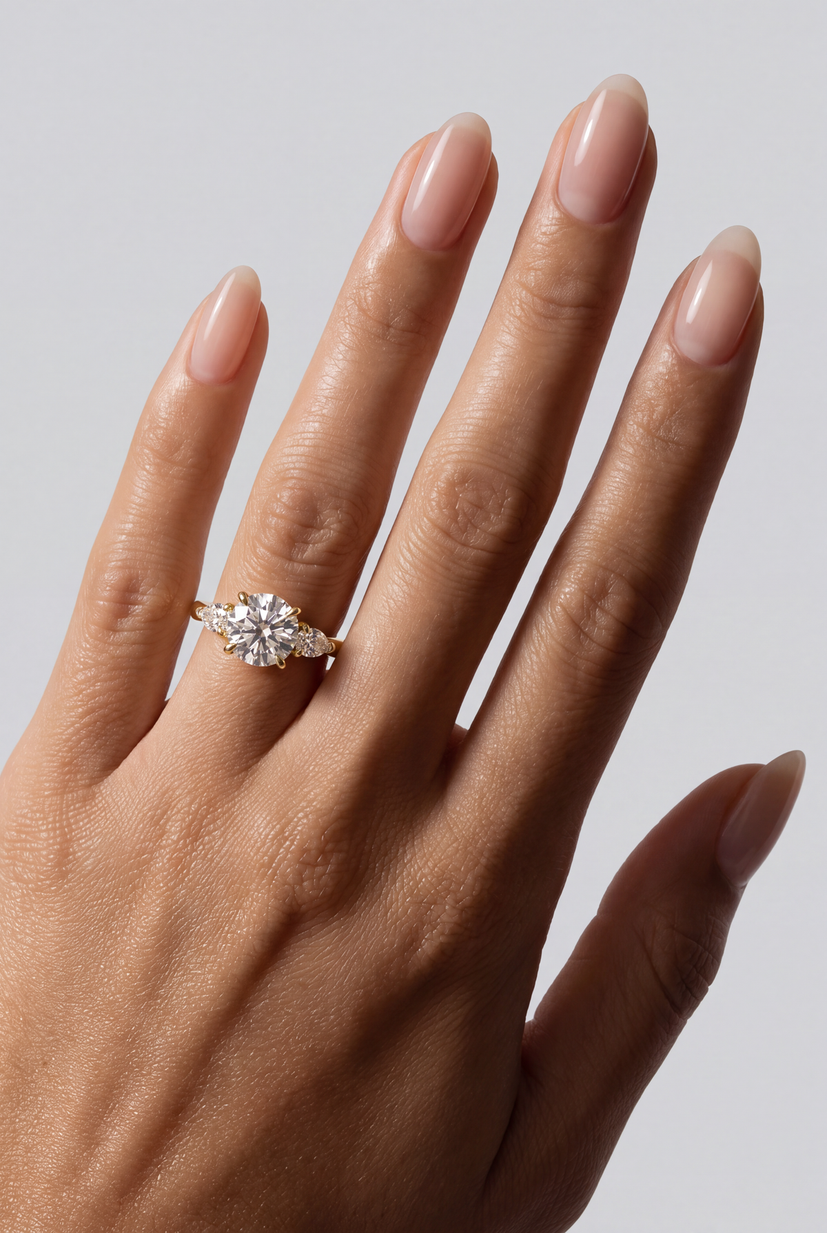 Sorelle – Runder Trilogy Verlobungsring in Gelbgold, getragen an der Hand | Élysée Diamonds