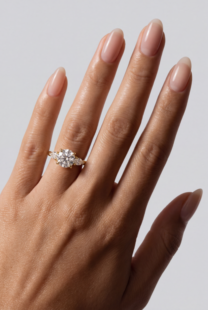 Sorelle – Runder Trilogy Verlobungsring in Gelbgold, getragen an der Hand | Élysée Diamonds