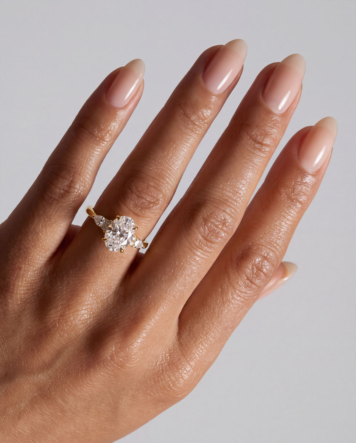 Souline – Ovaler Trilogy Verlobungsring in Gelbgold, getragen an der Hand | Élysée Diamonds