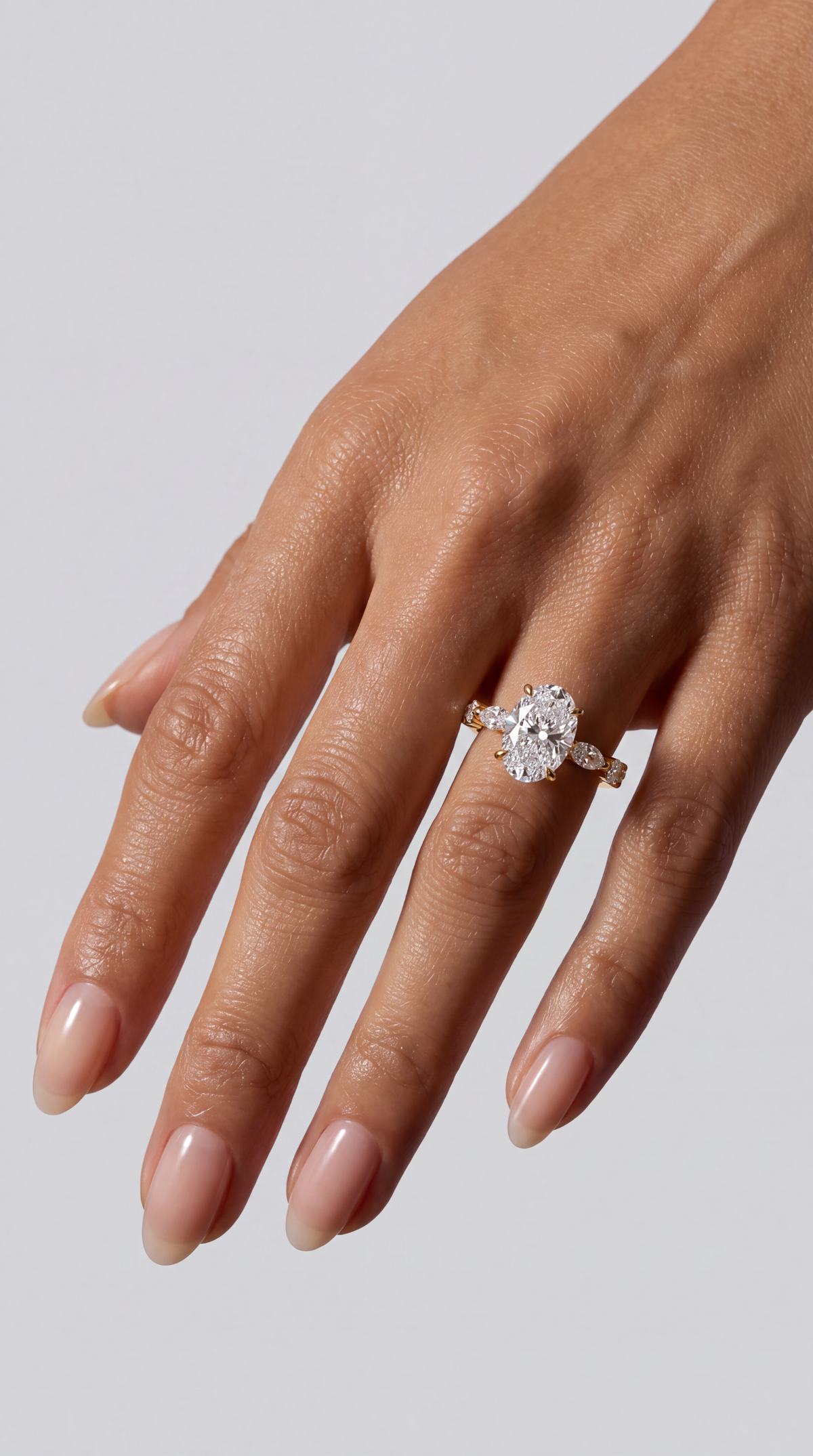 Étoile – Ovaler Solitär Verlobungsring mit Akzentsteinen in Gelbgold, getragen an der Hand | Élysée Diamonds