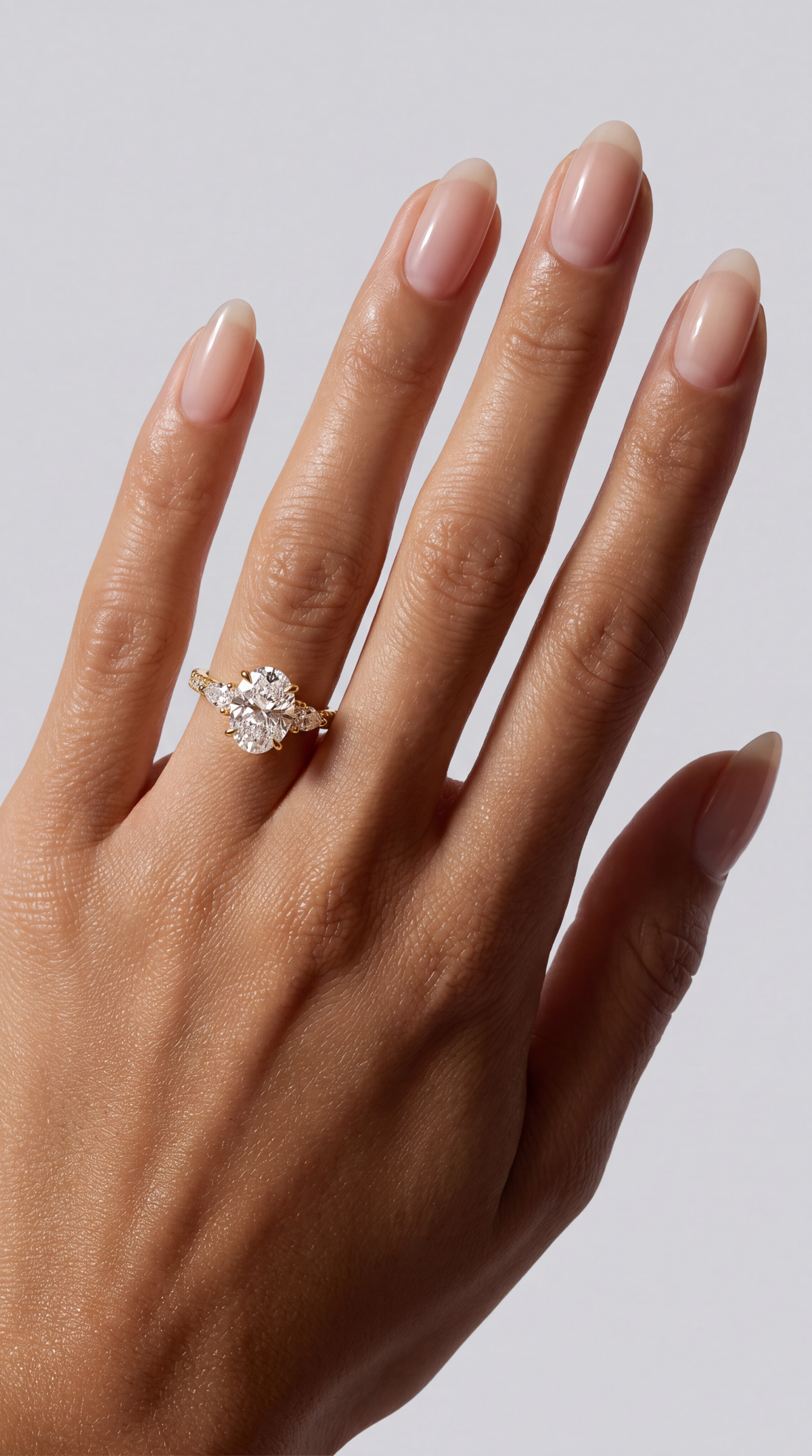 Serena – Ovaler Trilogy Verlobungsring mit Pavé in Gelbgold, getragen an der Hand | Élysée Diamonds