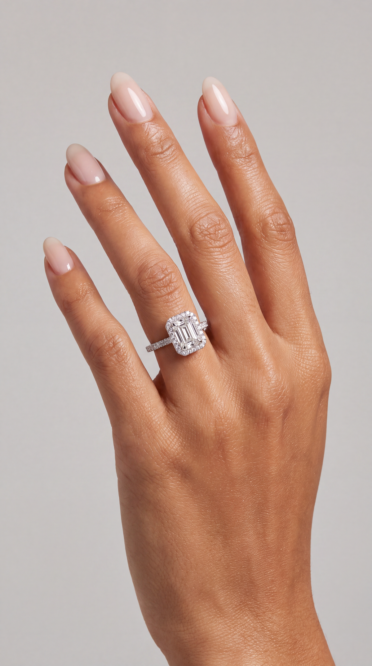 Elodie – Emerald Verlobungsring mit Halo & Pavé in Weißgold, getragen an der Hand | Élysée Diamonds