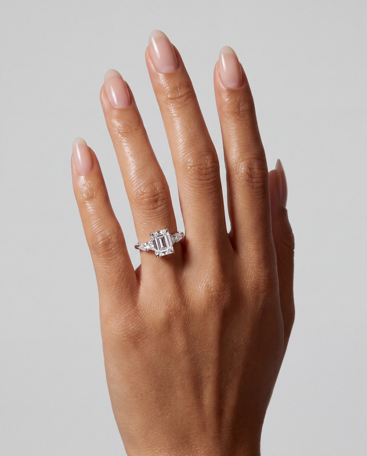 Aurora – Emerald Trilogy Verlobungsring in Weißgold, getragen an der Hand | Élysée Diamonds