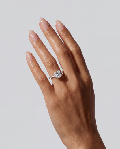Noémie – Cushion Verlobungsring mit Hidden Halo & Pavé in Weißgold, getragen an der Hand | Élysée Diamonds