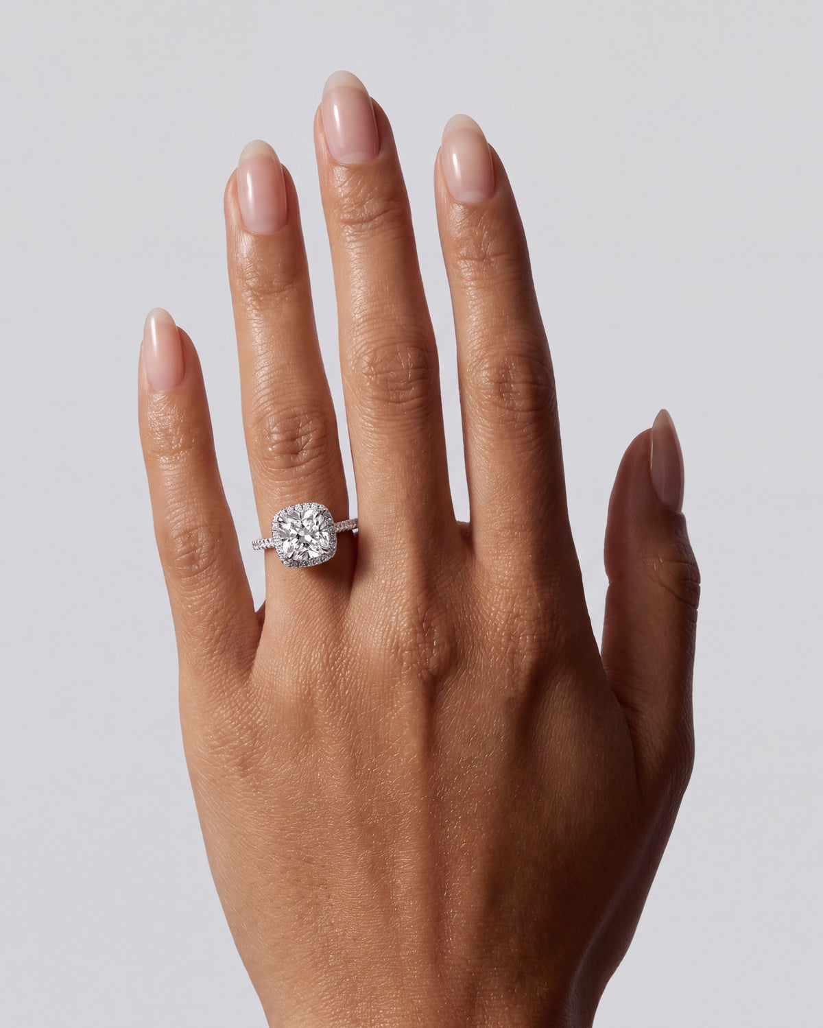 Capucine – Cushion Verlobungsring mit Halo & Pavé in Weißgold, getragen an der Hand | Élysée Diamonds