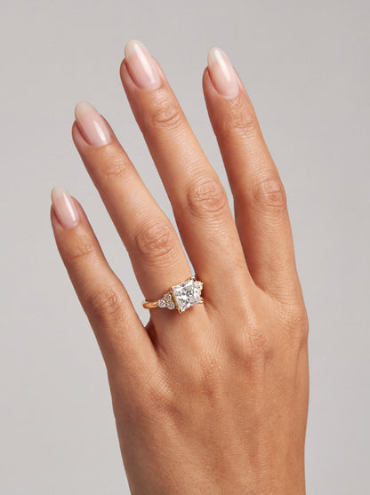 Marielle – Princess Verlobungsring mit Seitensteinen in Gelbgold, getragen an der Hand | Élysée Diamonds